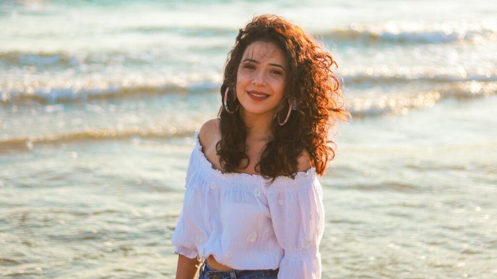 Donna al mare con capelli ricci lunghi