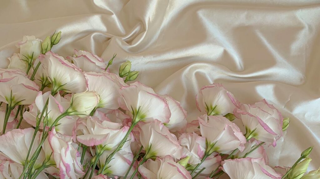 Fiori di lisianthus rosa e bianchi su tessuto di raso