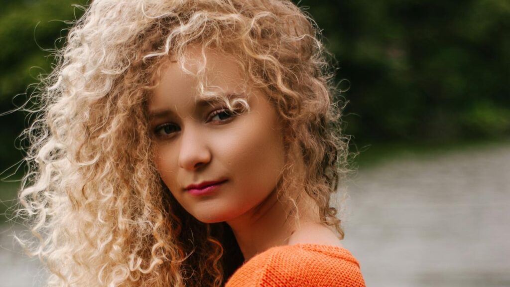 Giovane ragazza con capelli ricci biondi