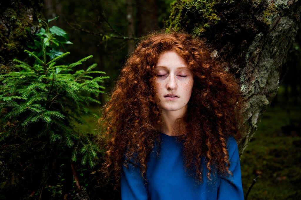 Ragazza con capelli ricci lunghi rossi