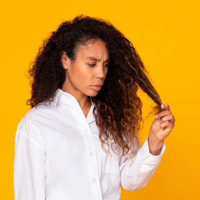 donna che tocca i suoi capelli secchi