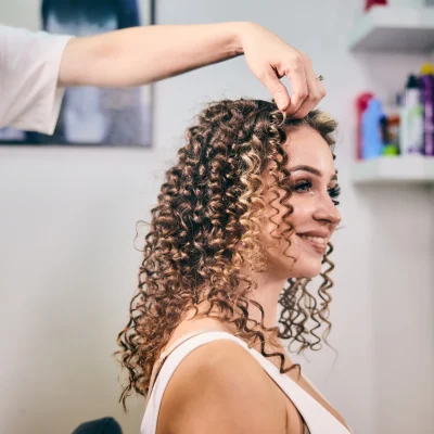 specialista capelli ricci acconcia i capelli di una cliente